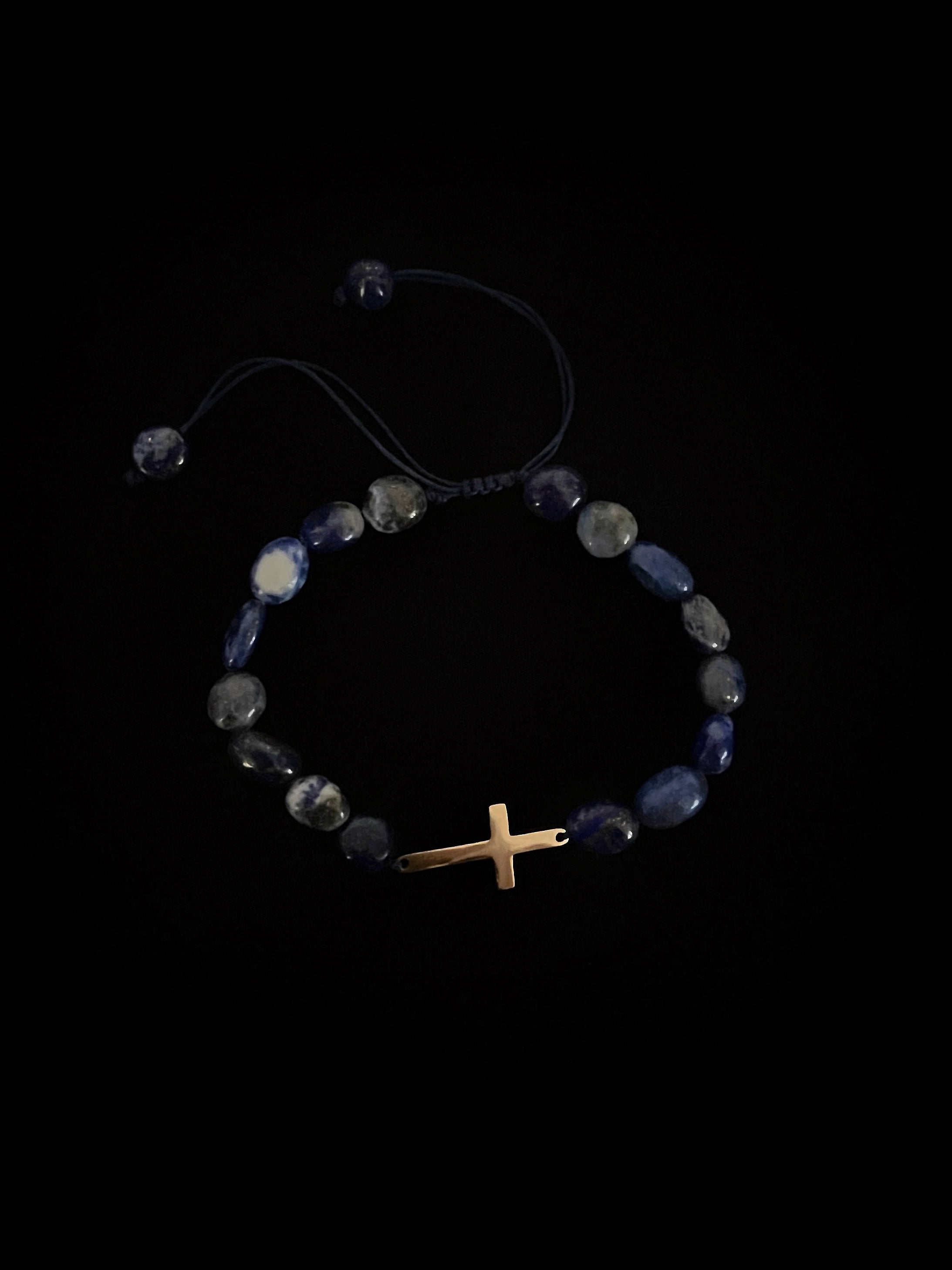 Bijou religieux moderne, bracelet en acier avec croix stylisée.