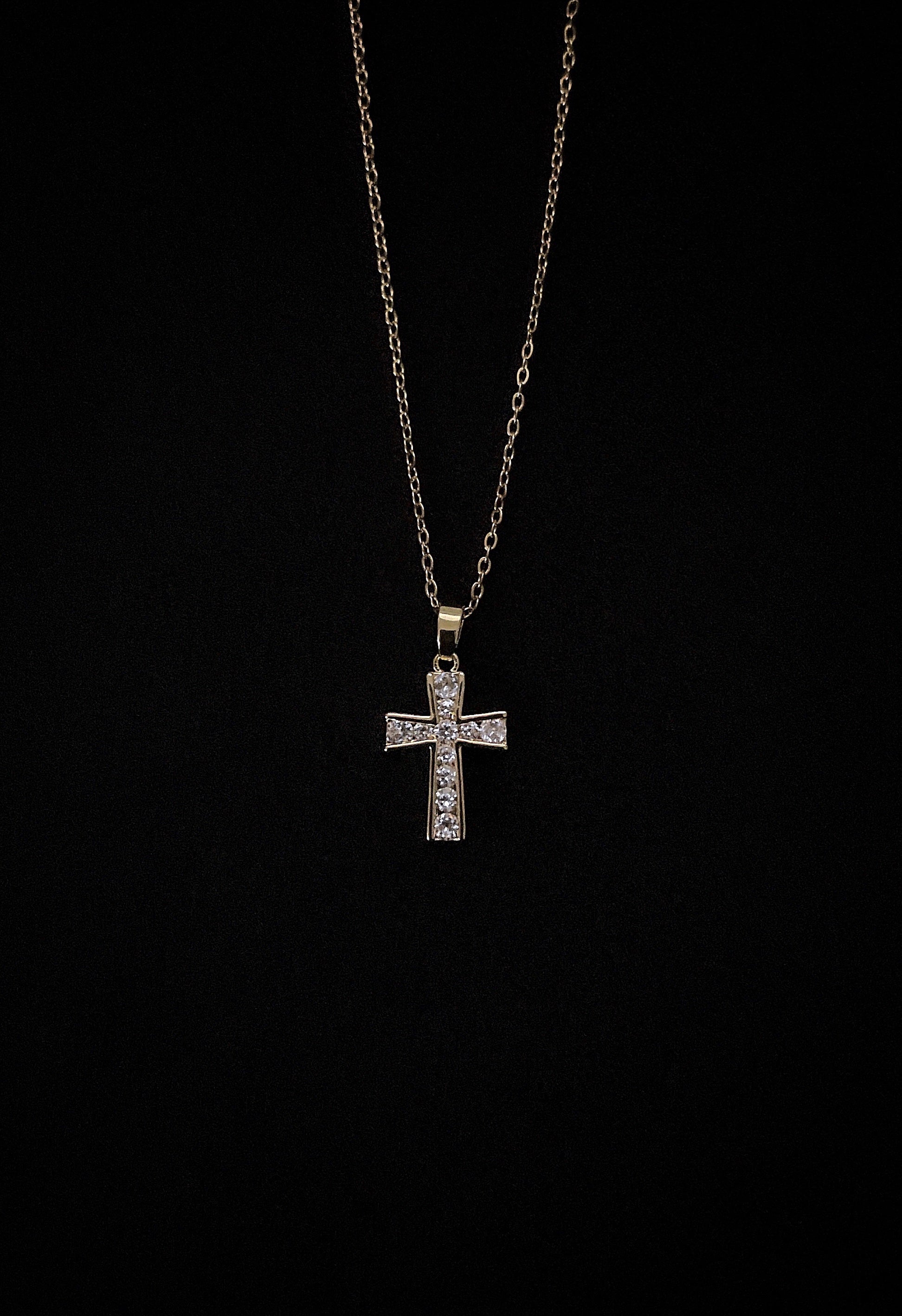 Bijou religieux plaqué or, croix lumineuse sur chaîne fine.