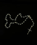 Chapelet religieux en argent, croix brillante et perles symboliques.